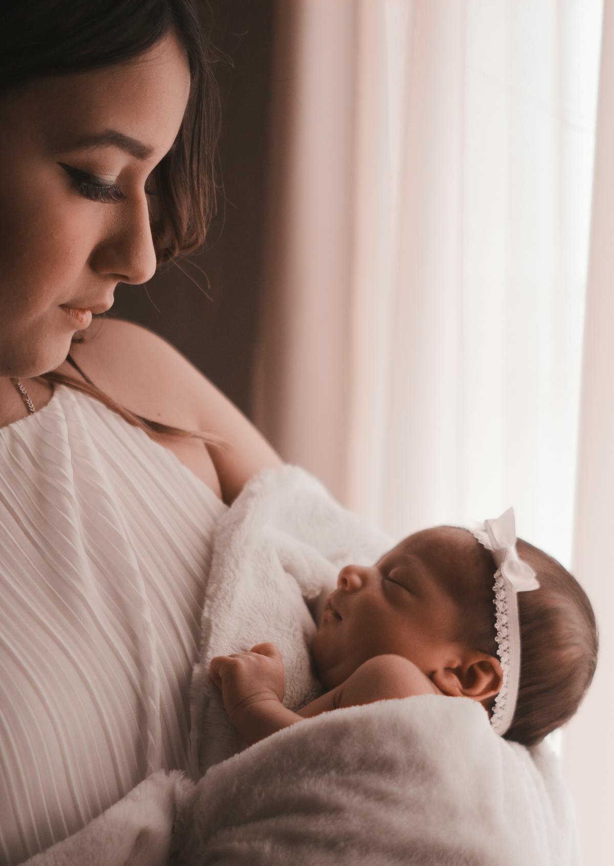 Mama trzymająca noworodka przy oknie