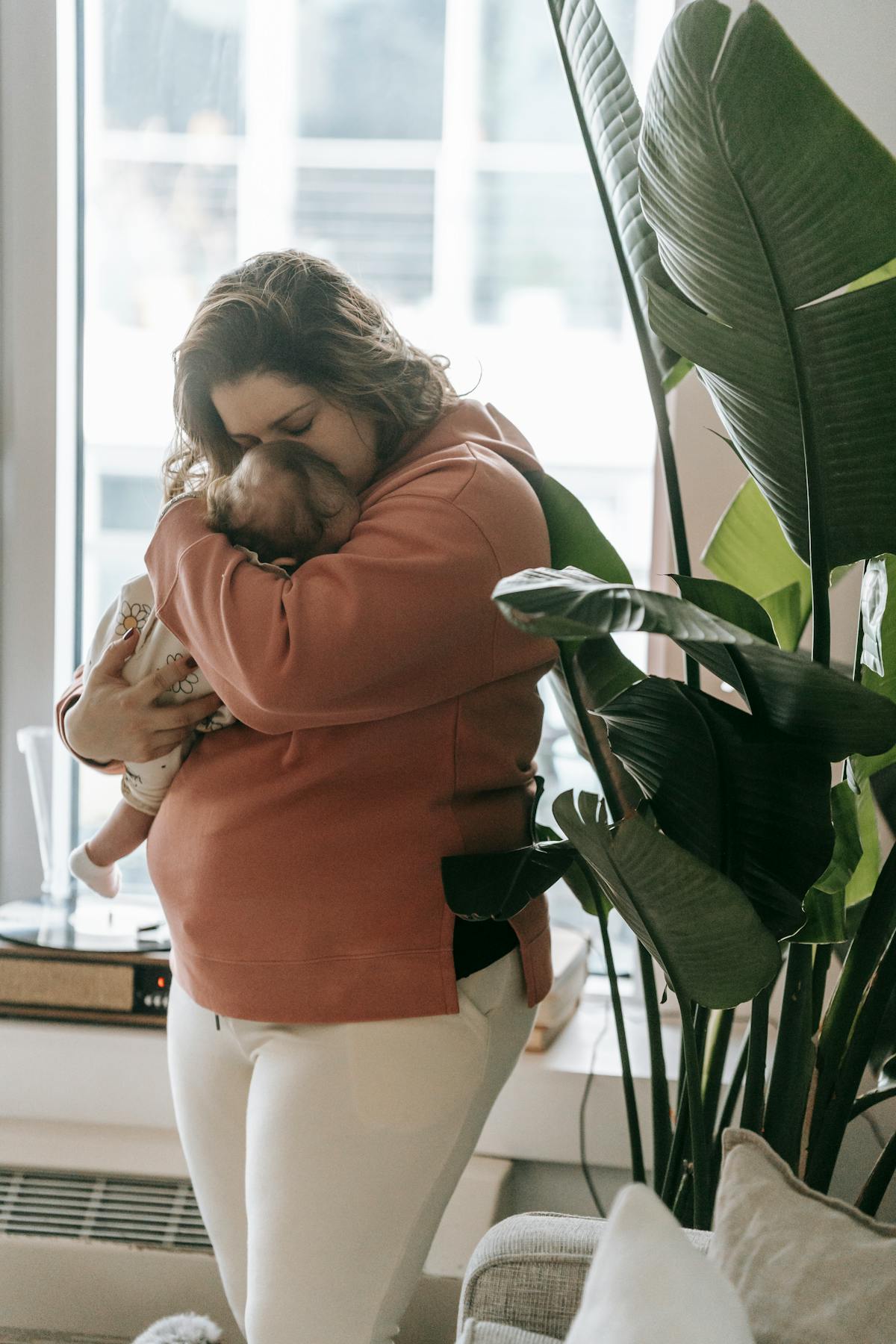 Mama w połogu całująca noworodka